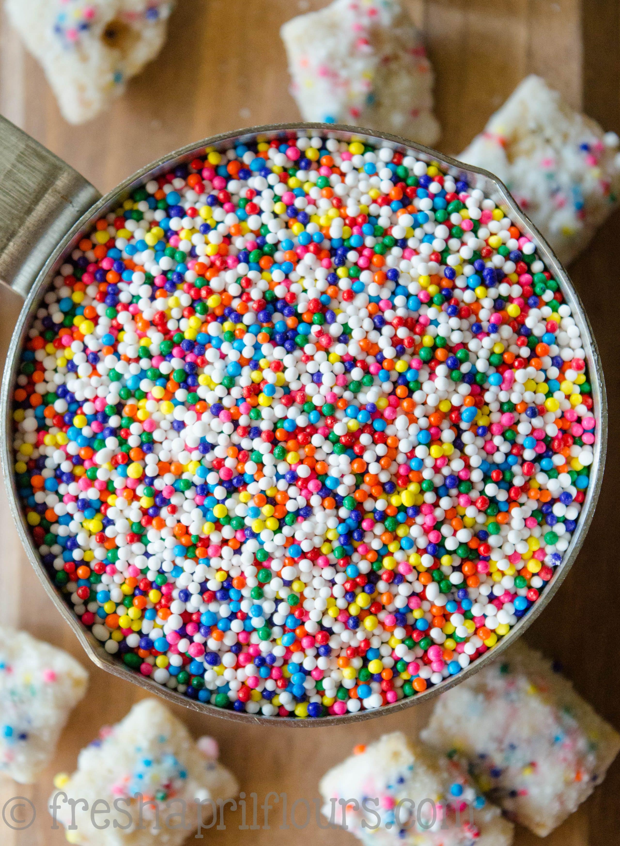 measuring cup full of rainbow nonpareils