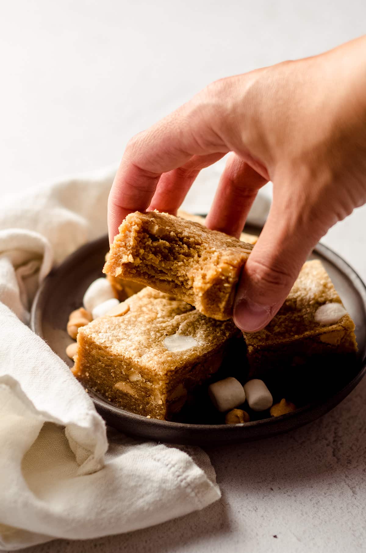 hand grabbing a fluffernutter bar with a bite taken out of it