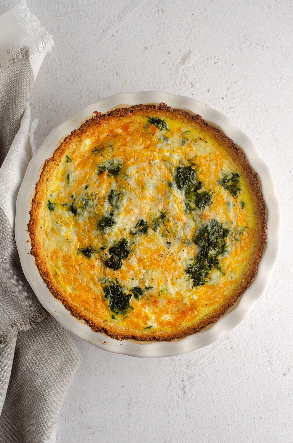 aerial photo of cheesy vegetable quiche with cauliflower crust in a pie plate