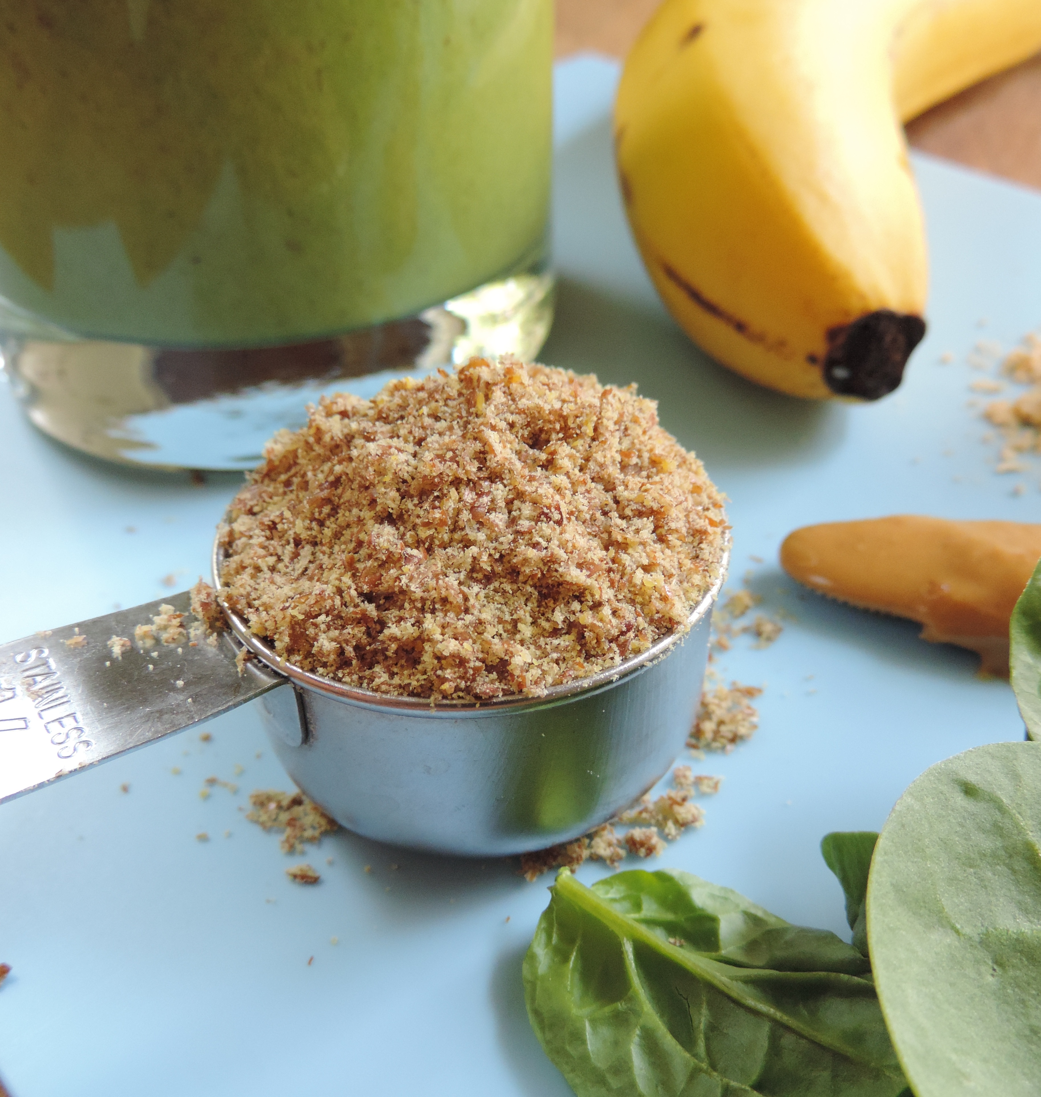 a scoop of flaxseed on a blue surface