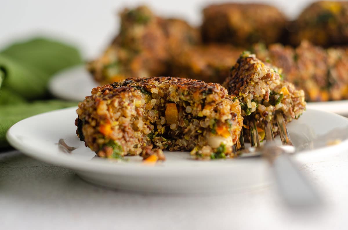 quinoa patty on a plate with a bite taken out with a fork