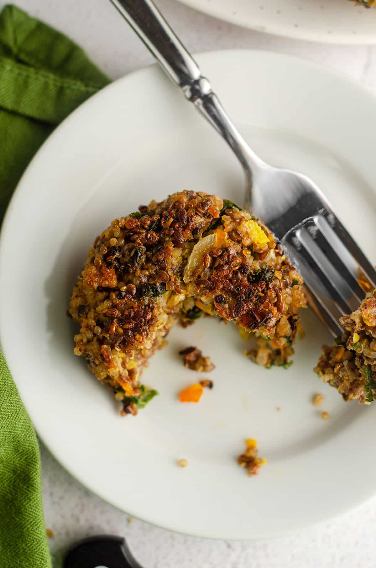 quinoa patty sitting on a plate with a bite taken out