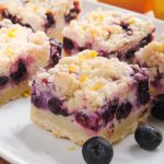 Blueberry Lemon Pie Bars: Creamy and sweet pie bursting with blueberries and citrusy lemon on top of shortbread crust. In portable bar form!