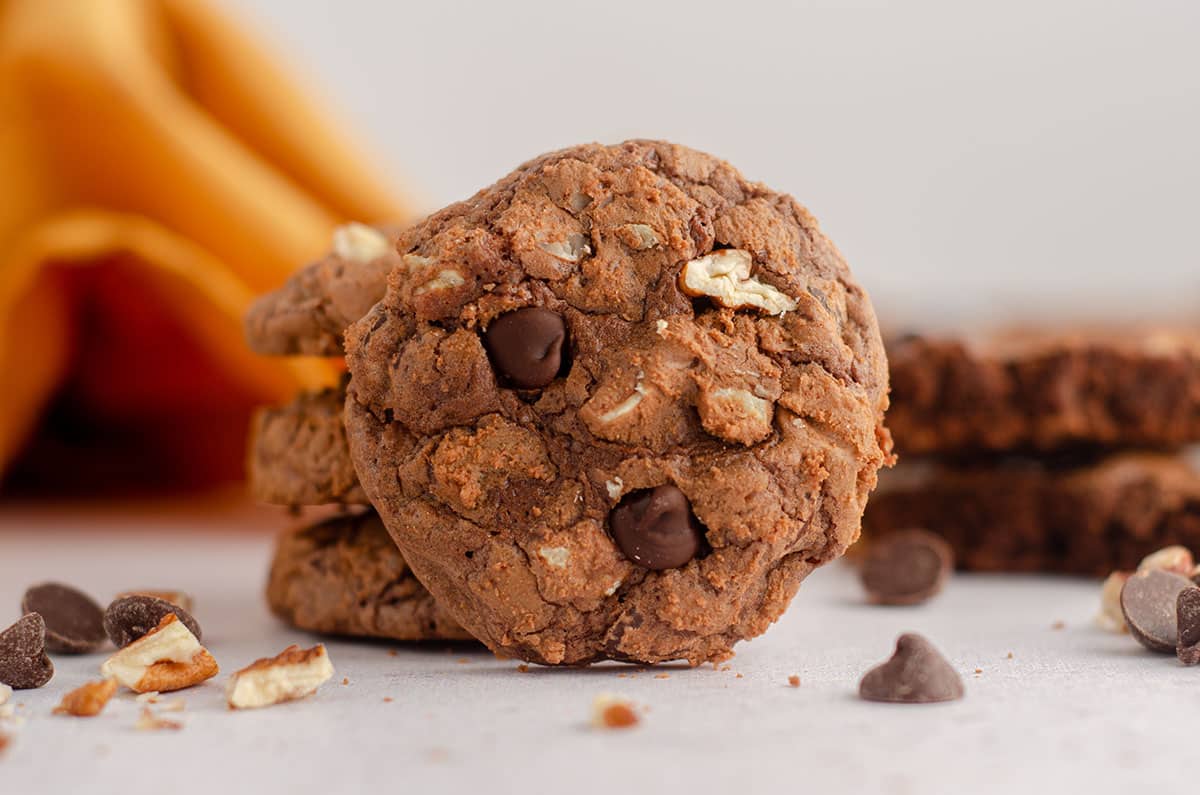 a brownie cookie leaning on a stack of other brownie cookies