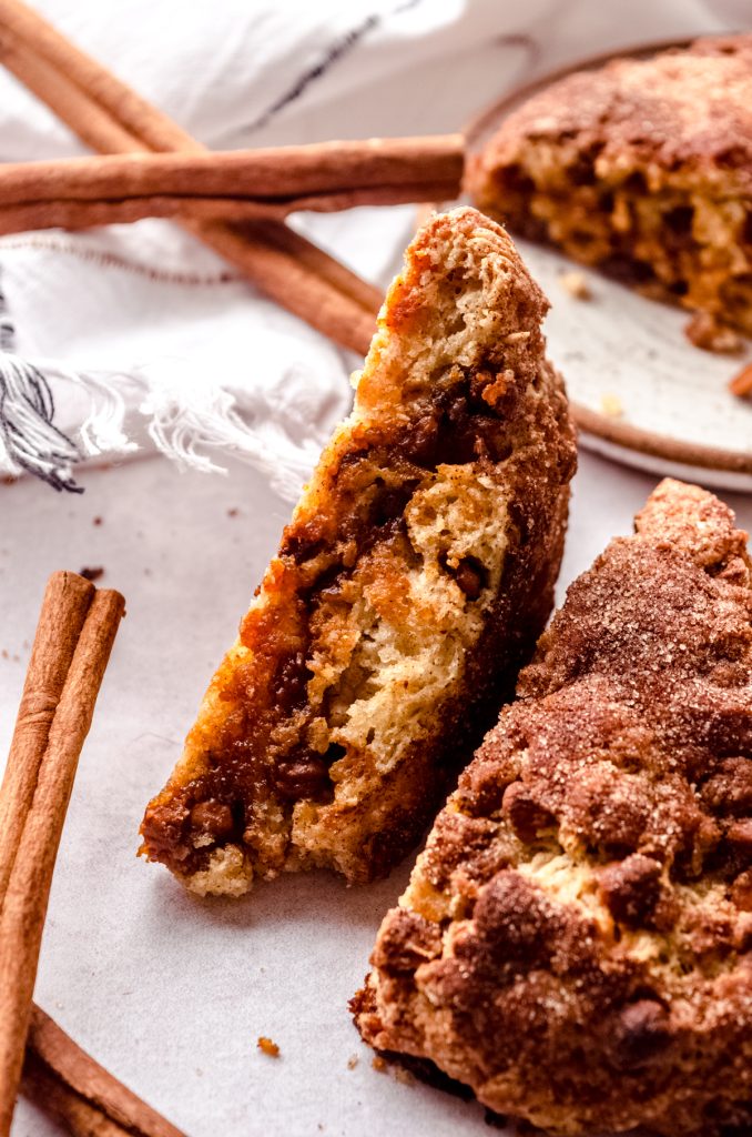 A cinnamon chip scone on its side so you can see the crisp edges.