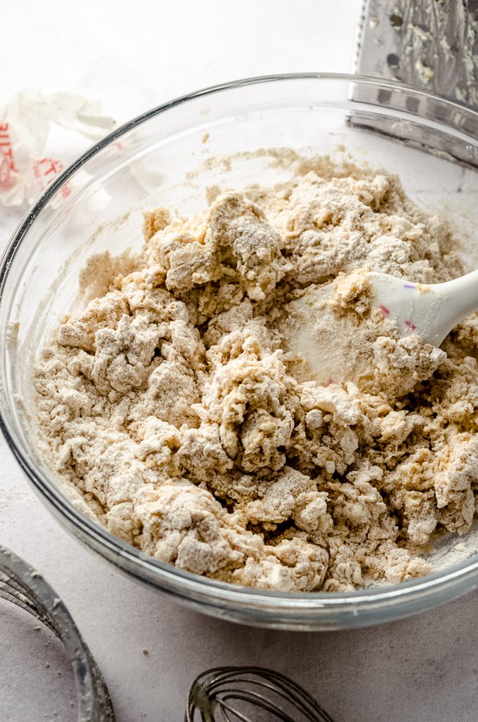 A bowl of scone dough with a spatula in it.