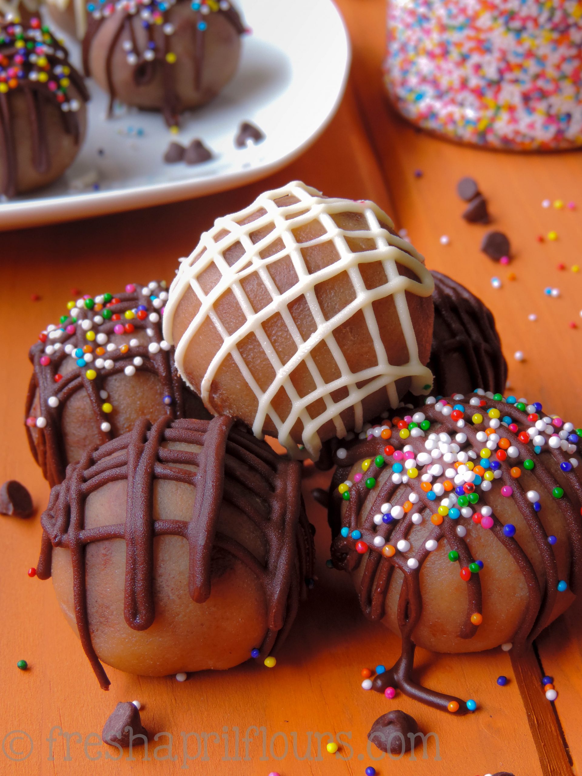 pile of cookie dough bites with sprinkles and chocolate decorating them