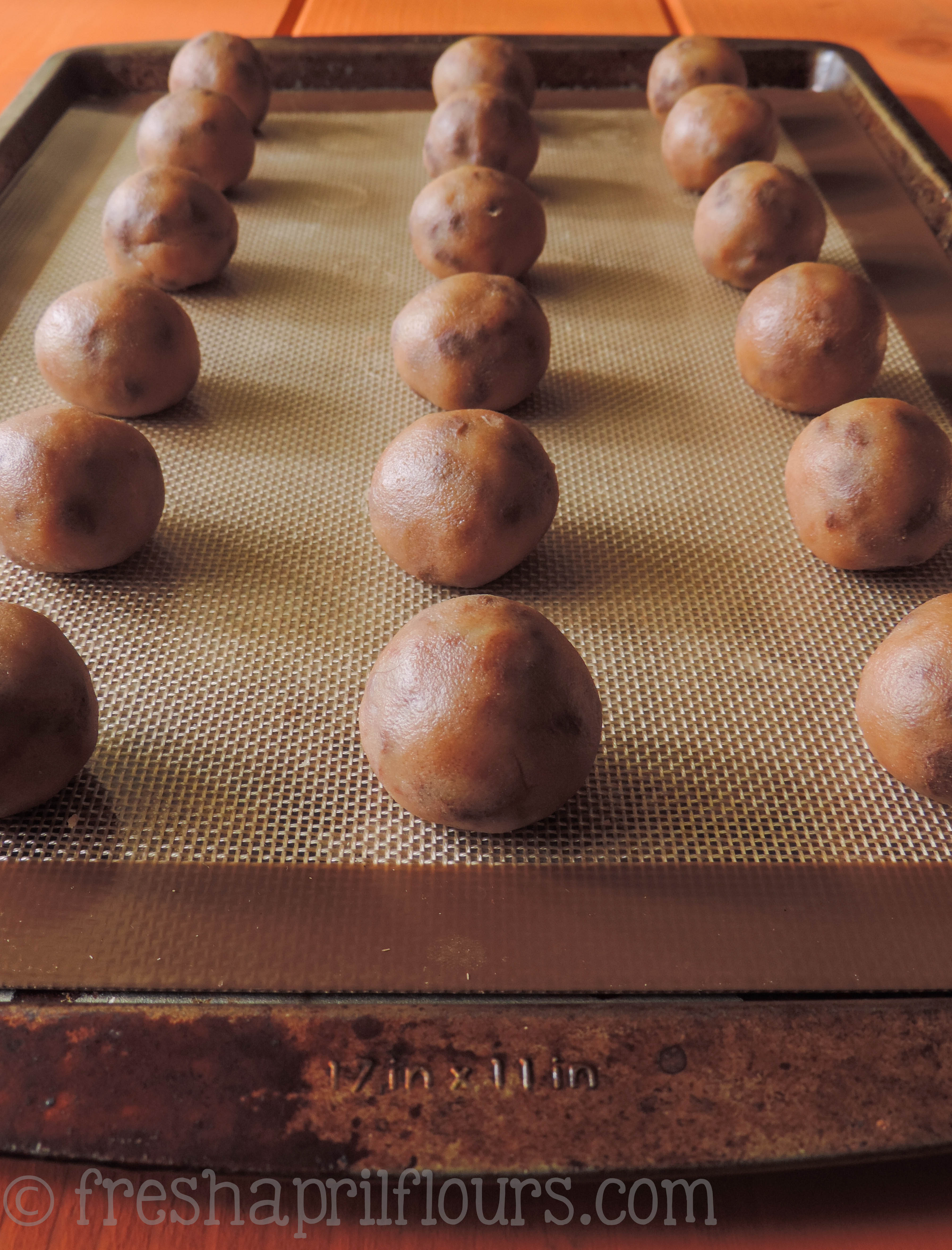 cookie dough balls on a baking sheet ready to chill