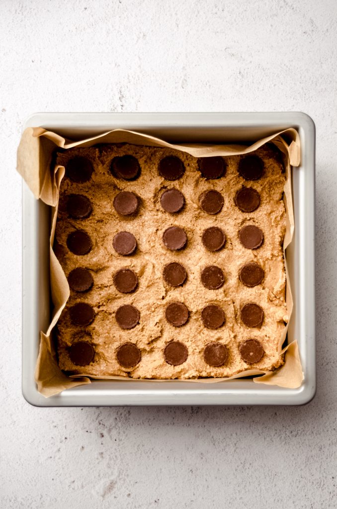 Aerial photo of the middle layer of peanut butter cups pressed into a baking pan to make peanut butter bars.