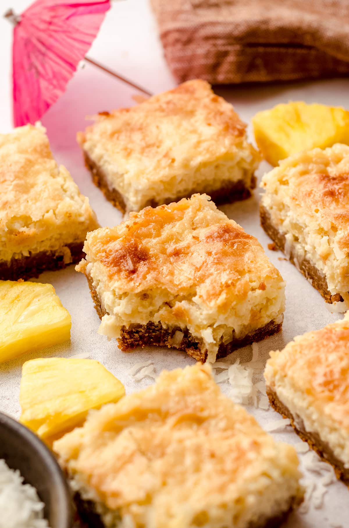 piña colada squares with one that has a bite taken out of it