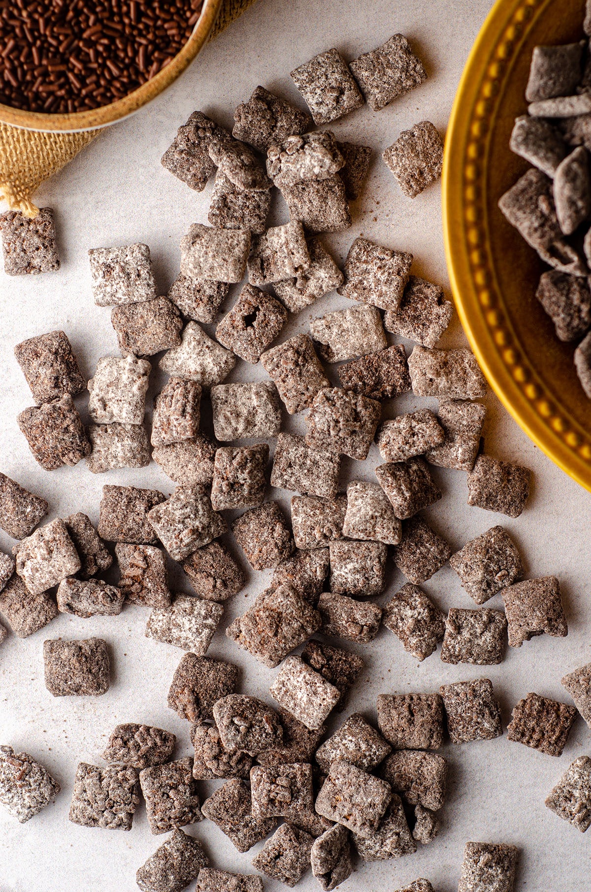 aerial photo of brownie batter puppy chow scattered on a white surface