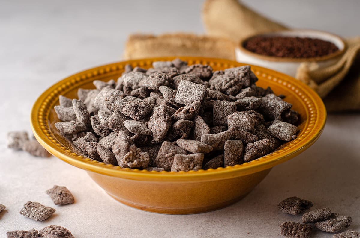 brownie batter puppy chow in a golden yellow bowl