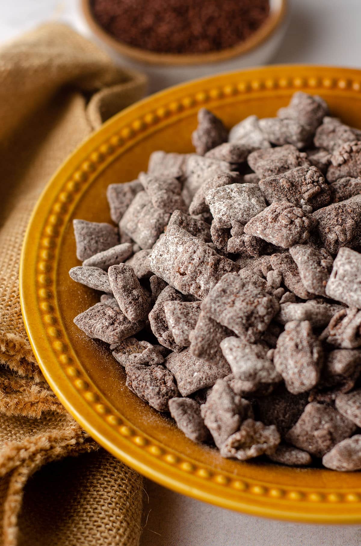 brownie batter puppy chow in a golden yellow bowl