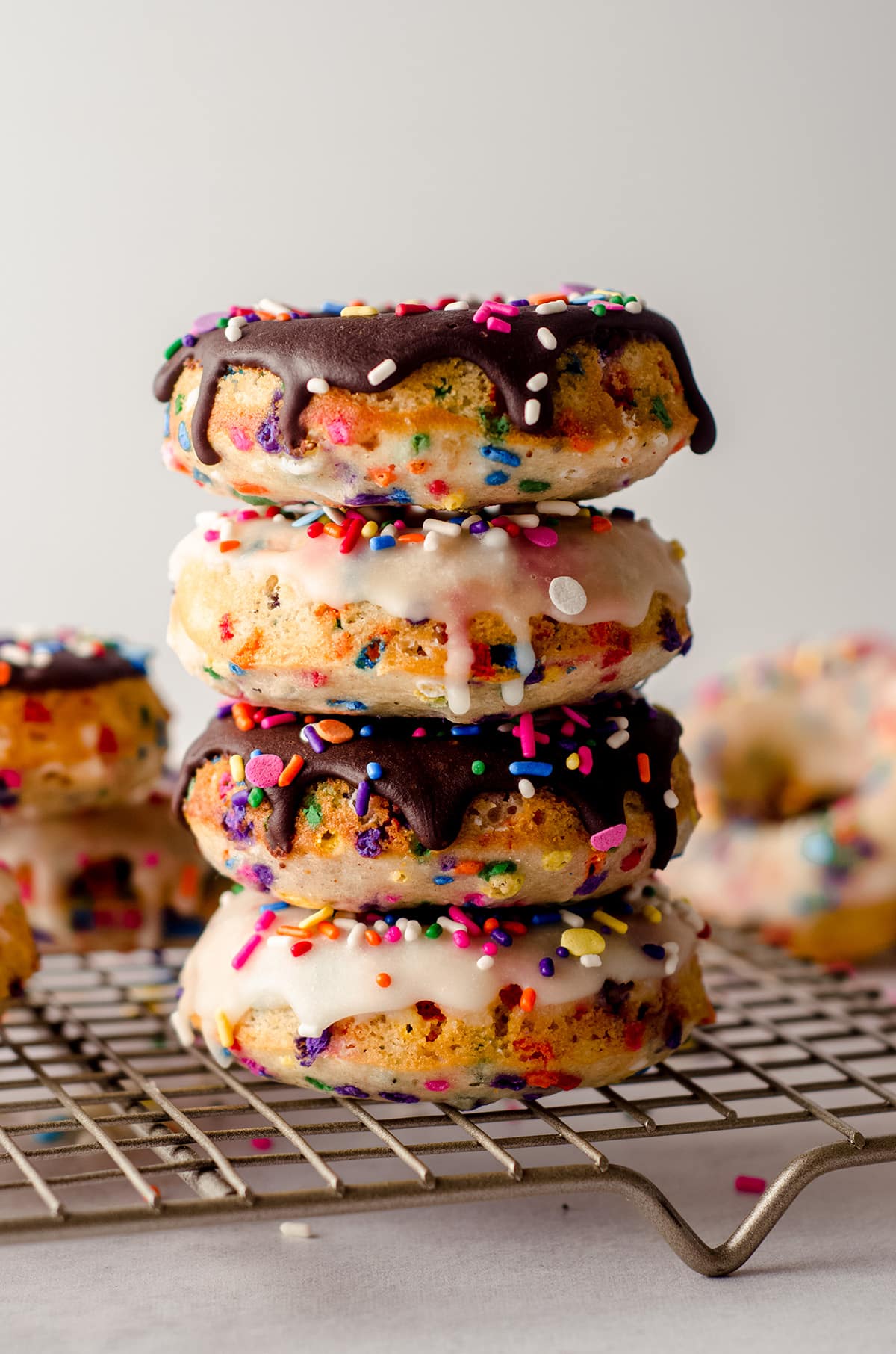 stack of funfetti donuts on a cooling rack