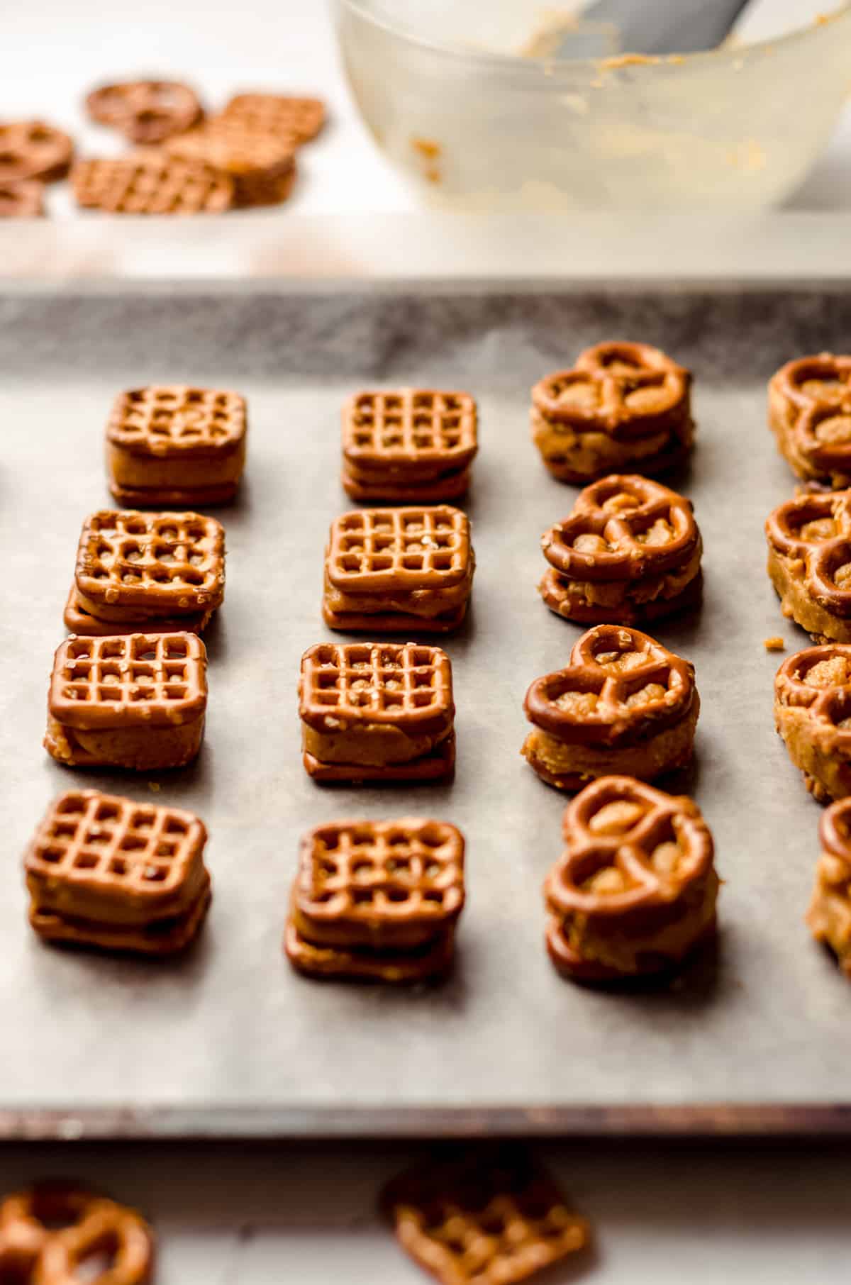 pumpkin peanut butter pretzel bites lined up on a baking sheet