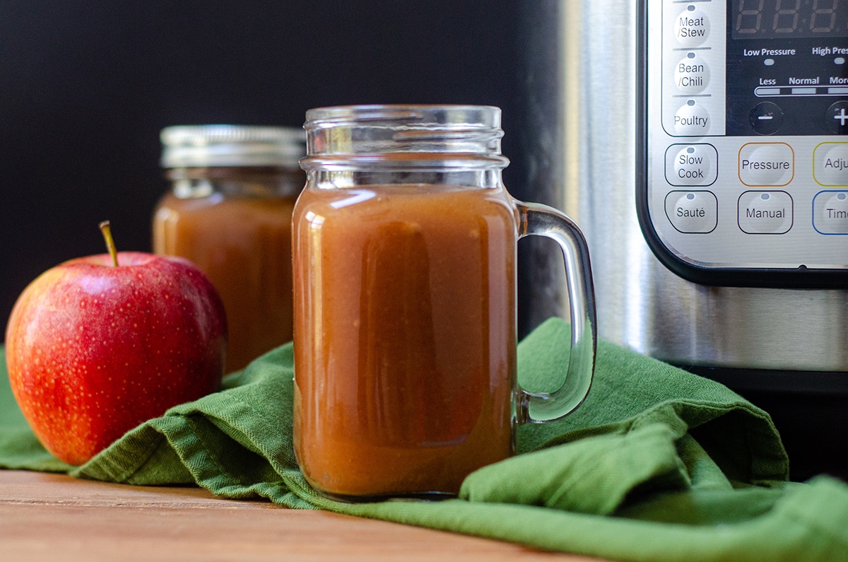 apple butter in a jar with an instant pot in the background