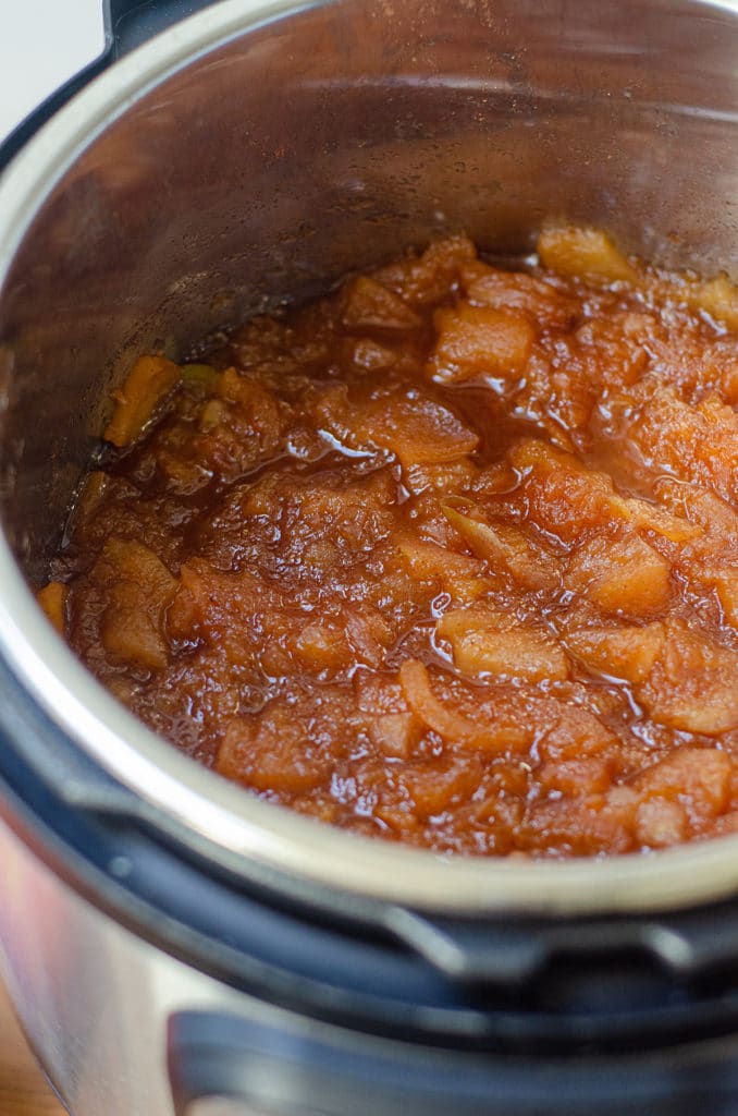 Cooked apples with spices in the drum of an Instant Pot ready to be blended to make apple butter.