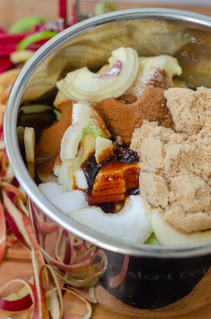 Sliced apples, sugar, spices, and molasses in the drum of an Instant Pot ready to make apple butter.