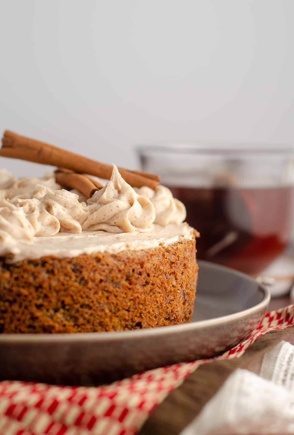 side view of chai cake with cup of chai tea in background