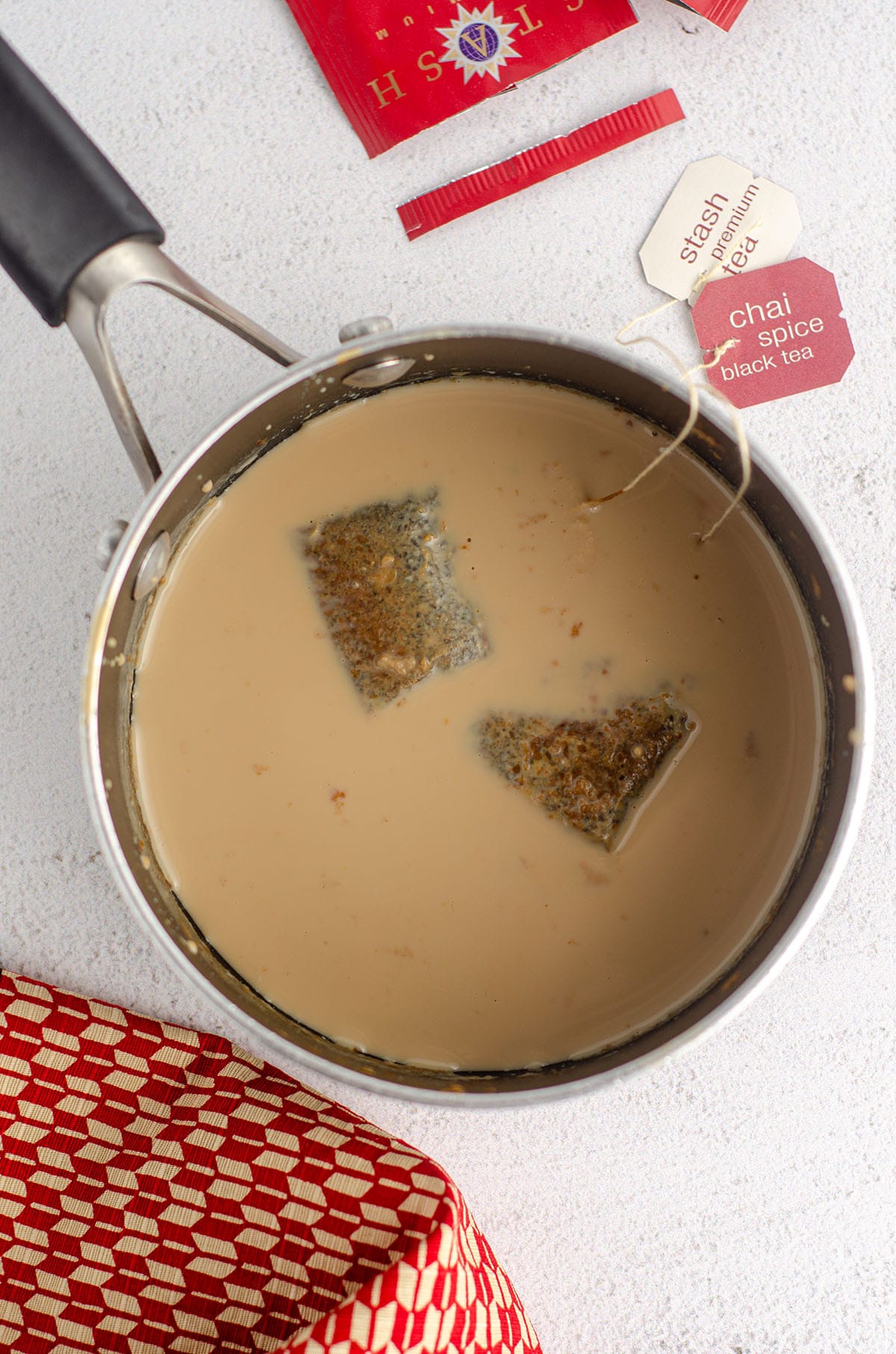 aerial view of chai tea bags steeping in milk in a pot