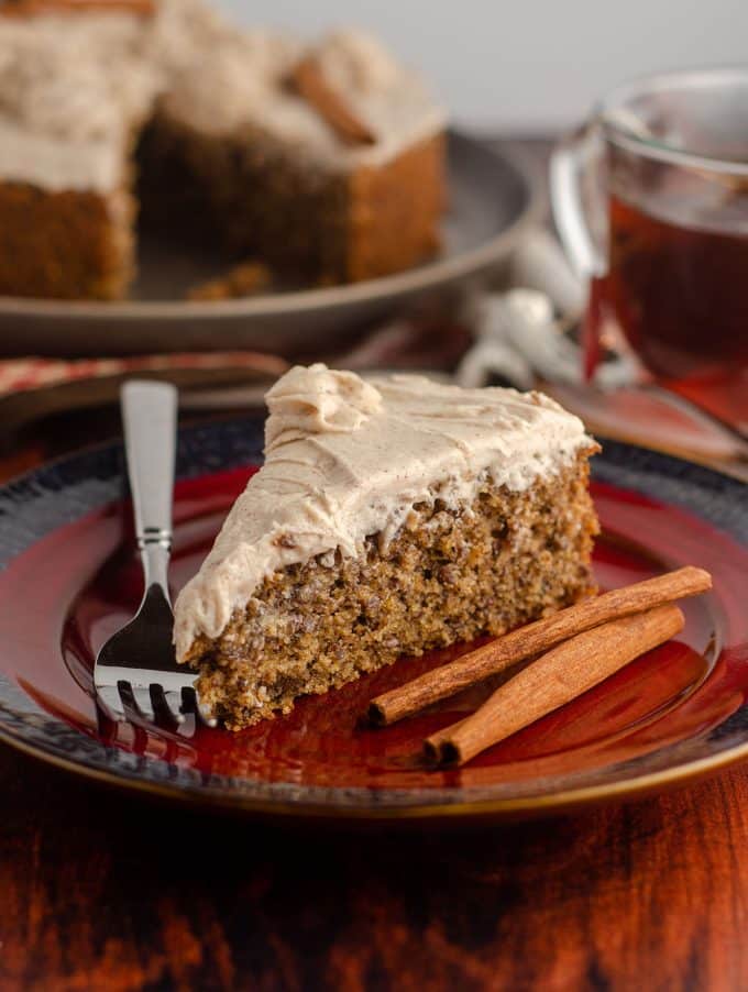 side view of slice of chai cake with cinnamon sticks and a fork