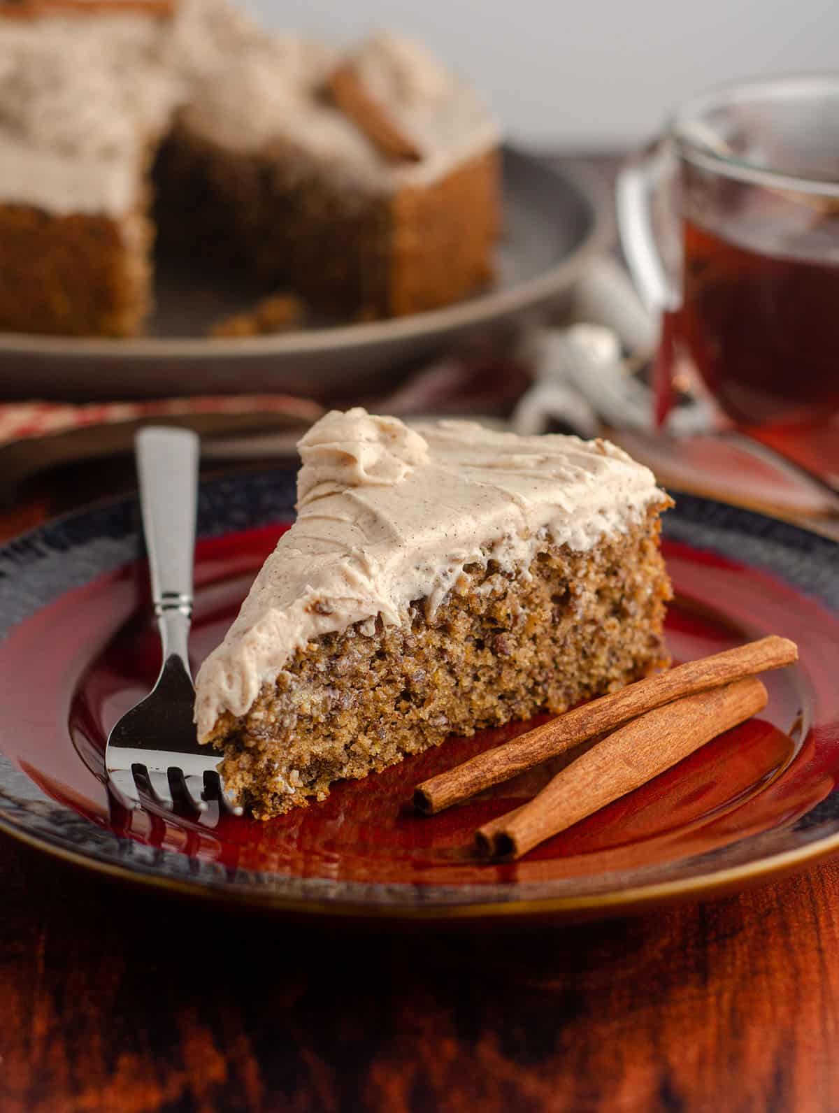 side view of slice of chai cake with cinnamon sticks and a fork