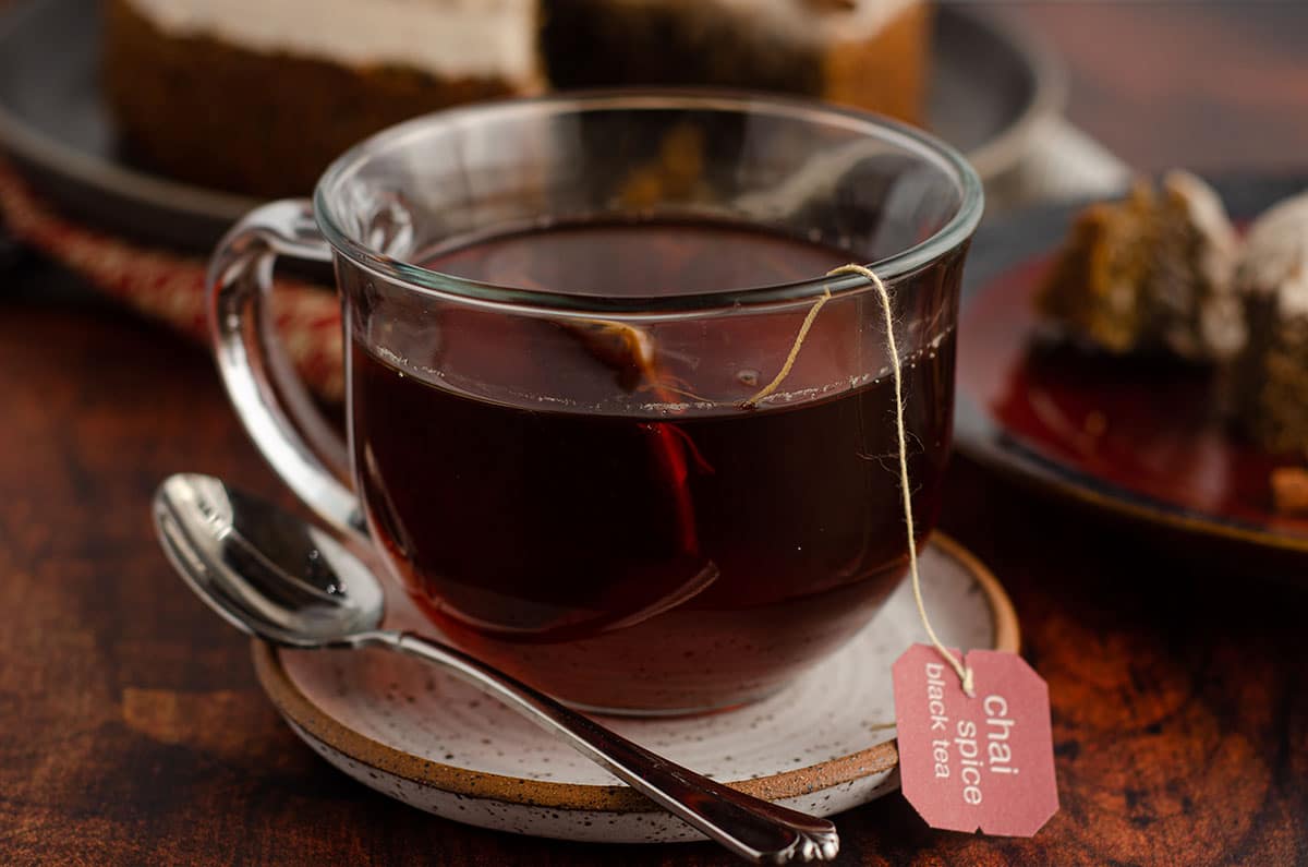 cup of chai tea on a saucer with a spoon