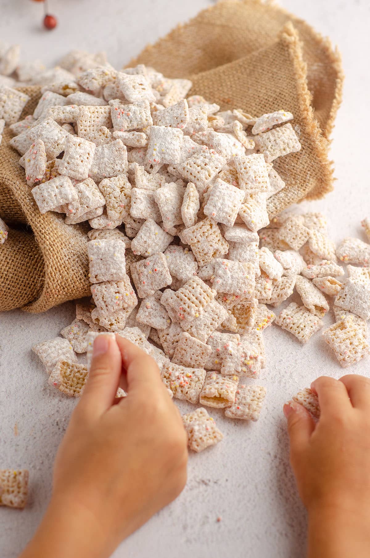 two little hands grabbing pumpkin spice puppy chow