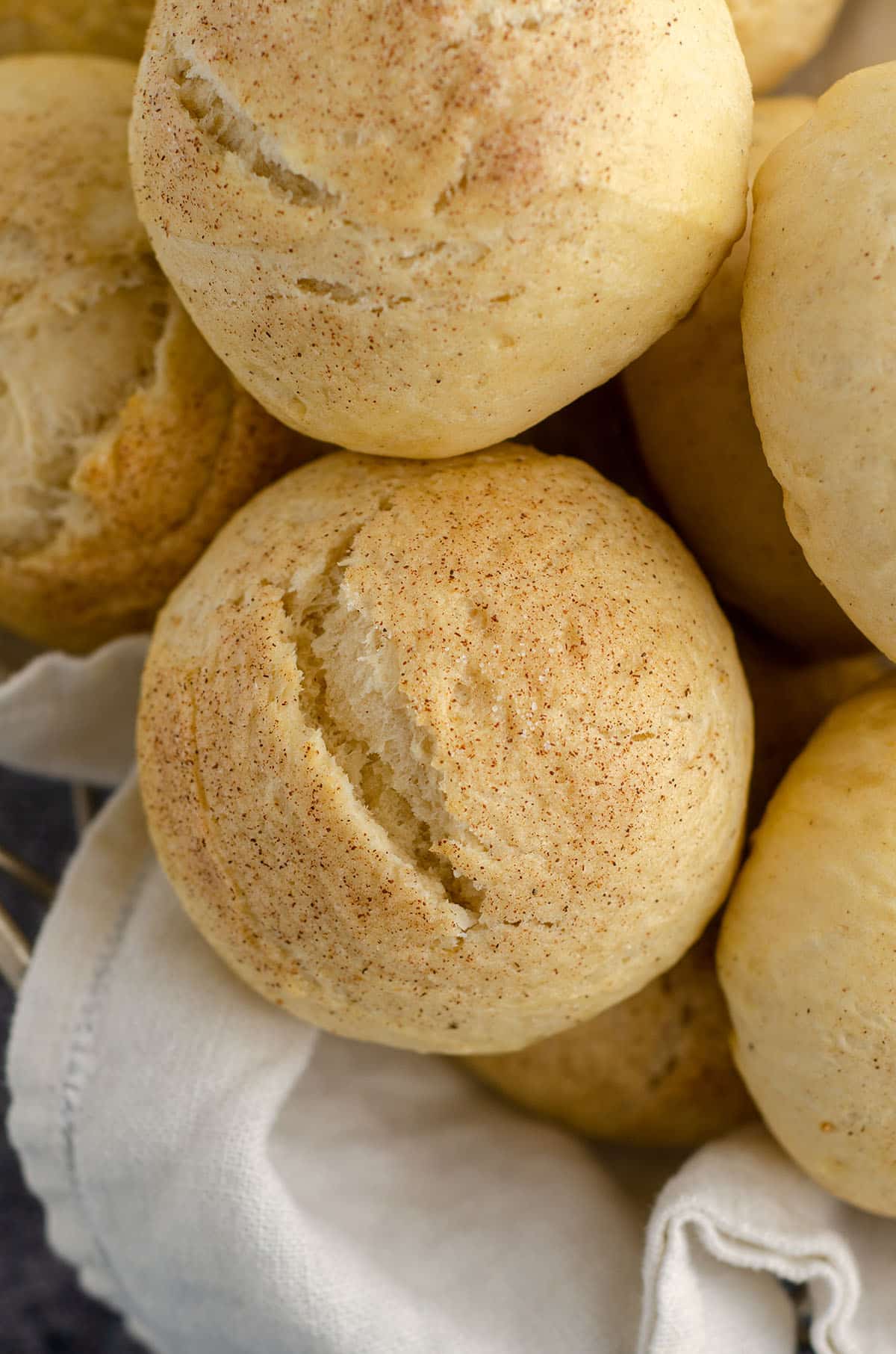 cardamom rolls sitting in a basket with a white kitchen cloth