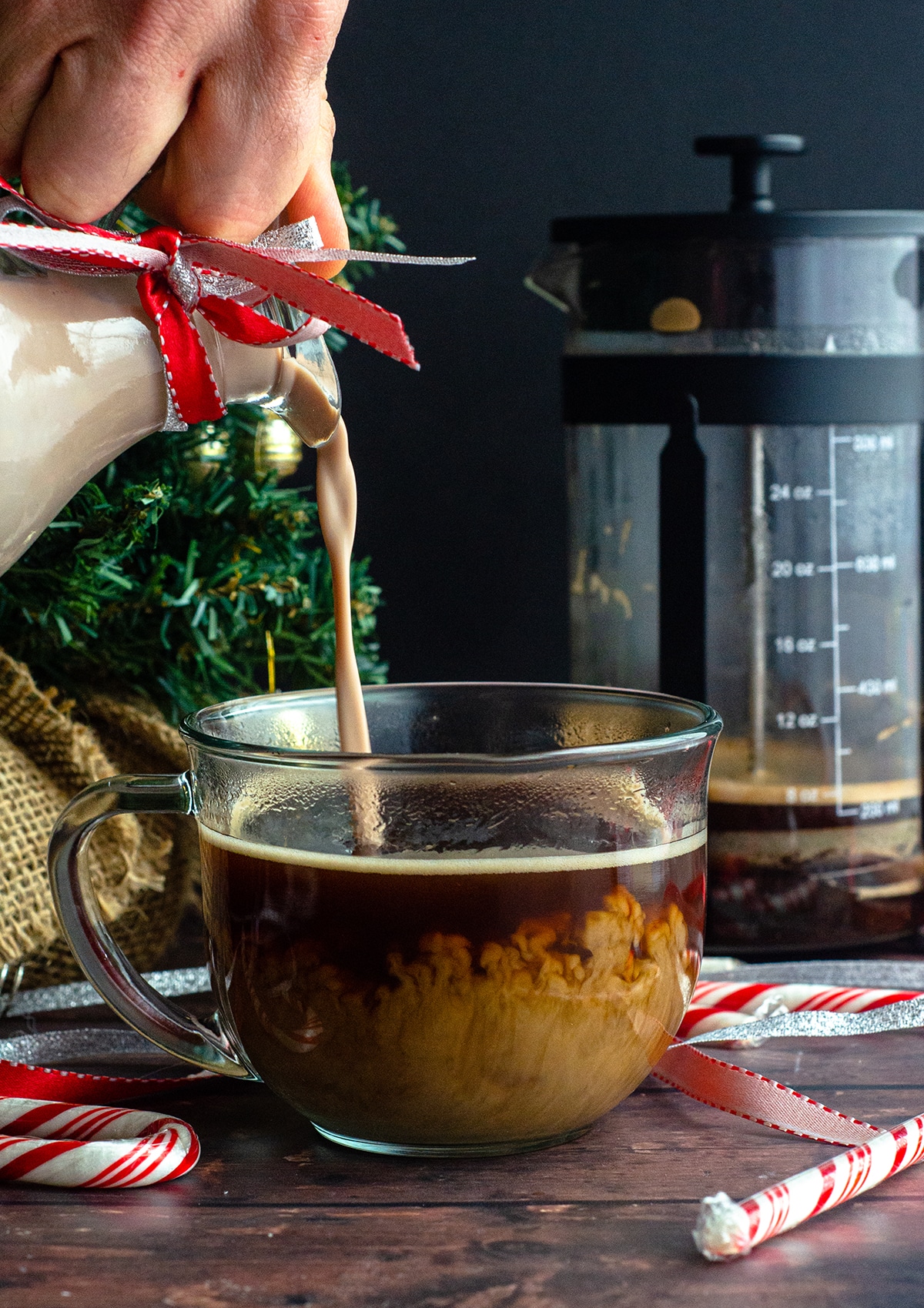 pouring peppermint mocha coffee creamer into a cup of coffee