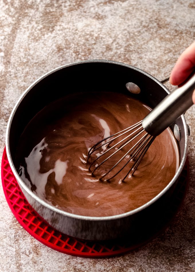 A saucepan of homemade peppermint mocha coffee creamer that someone is whisking together.