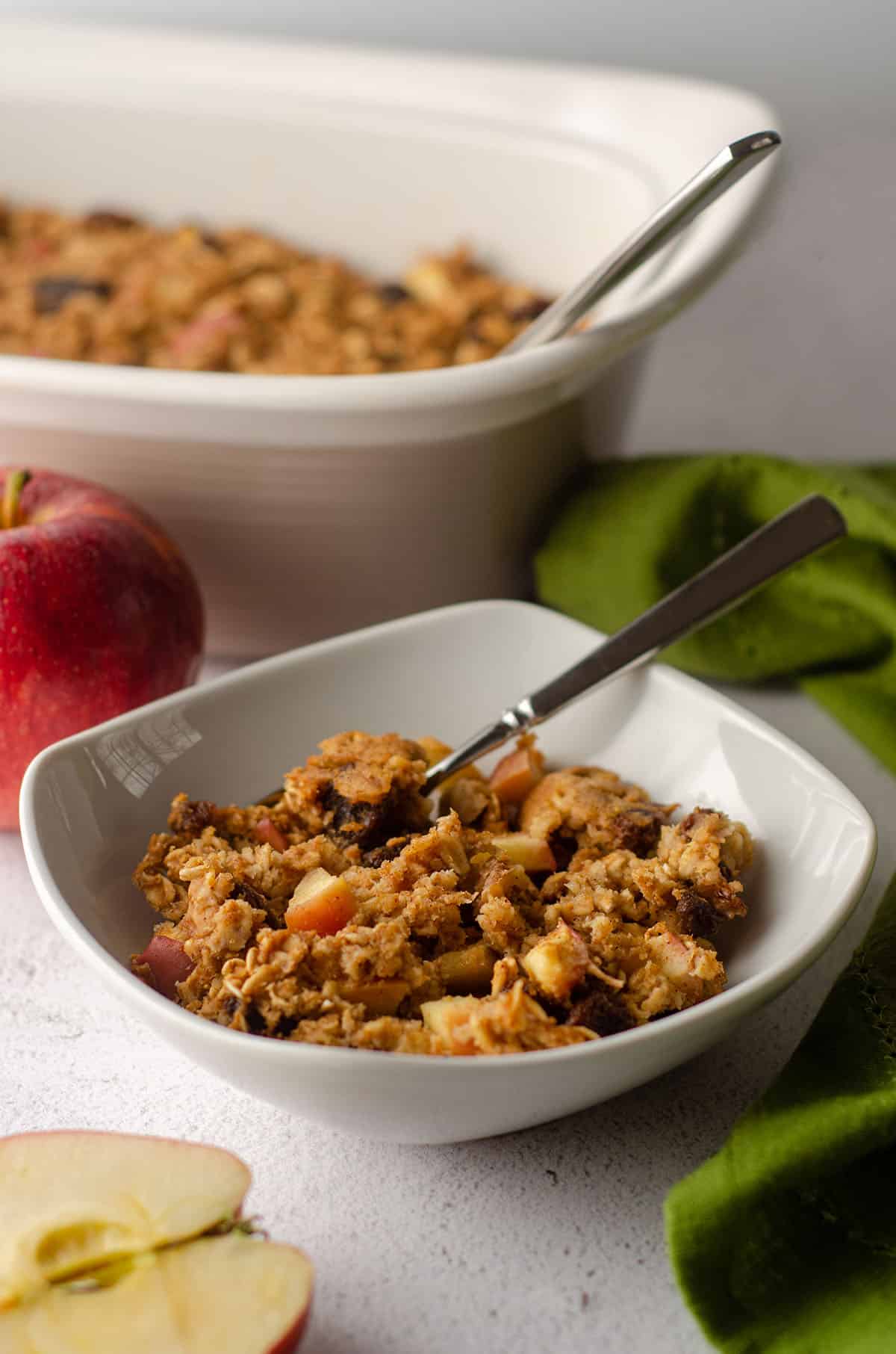 baked apple oatmeal in a white bowl with a spoon