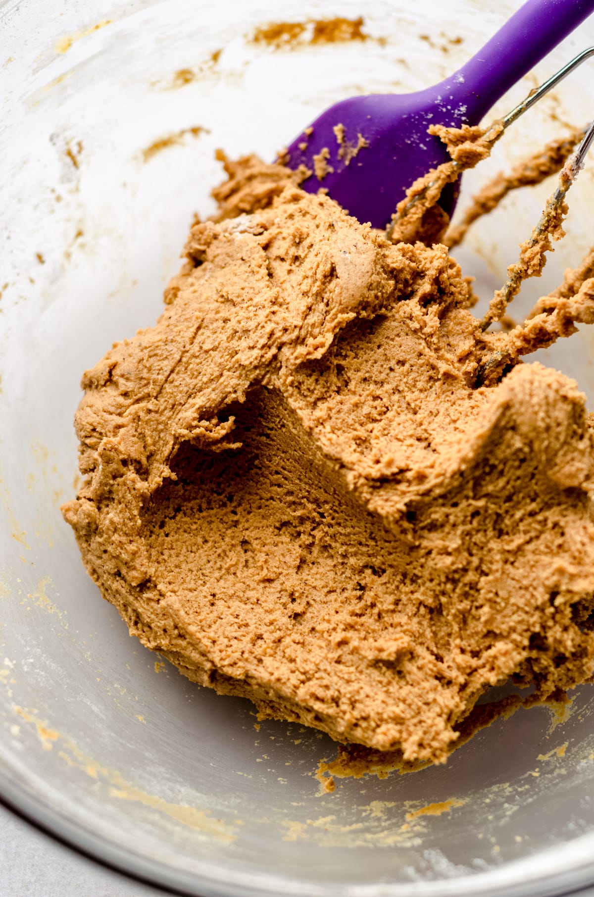 gingerbread cookie dough in a bowl with a purple spatula