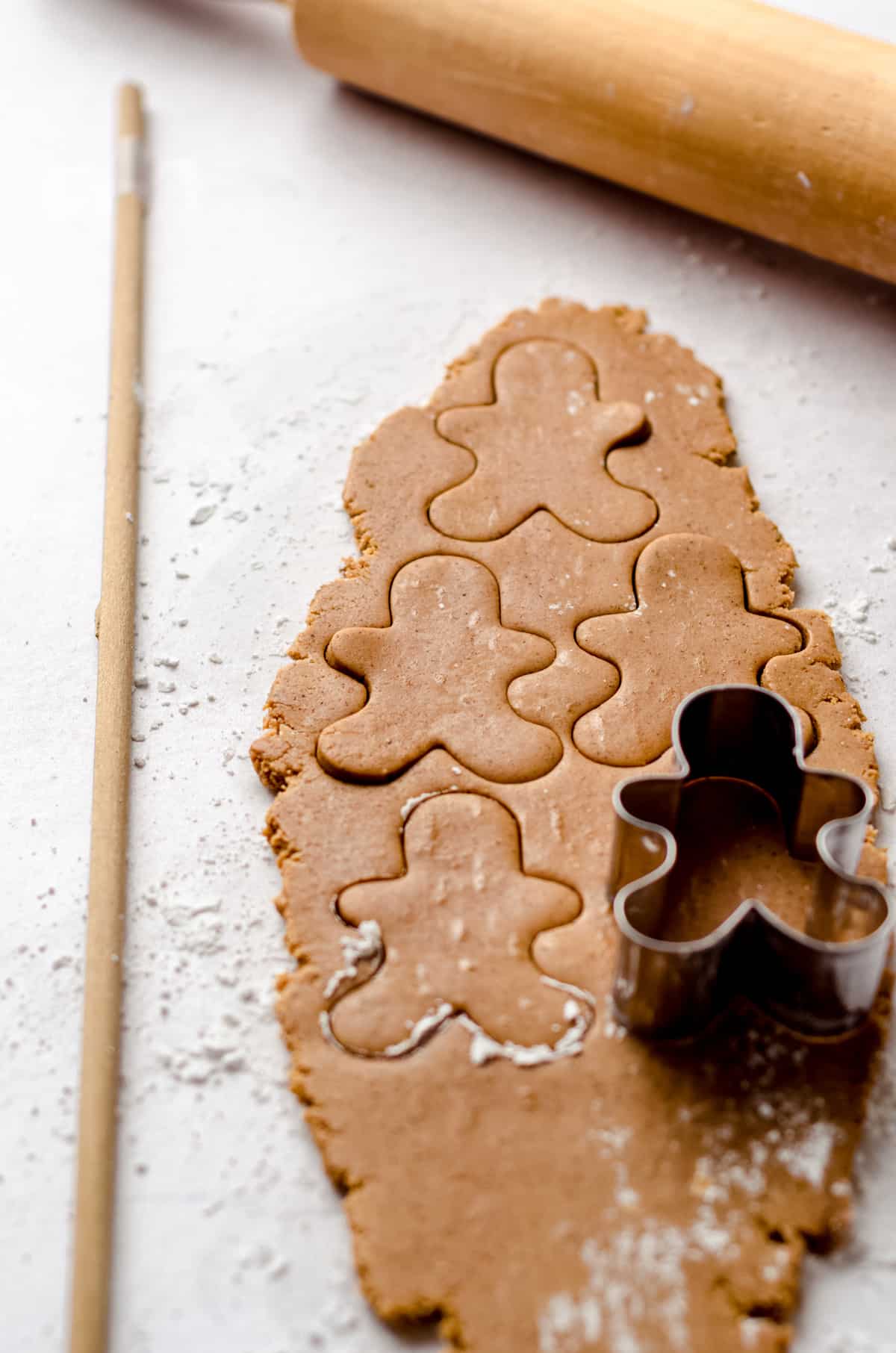 rolled gingerbread cookie dough being cut with a cookie cutter