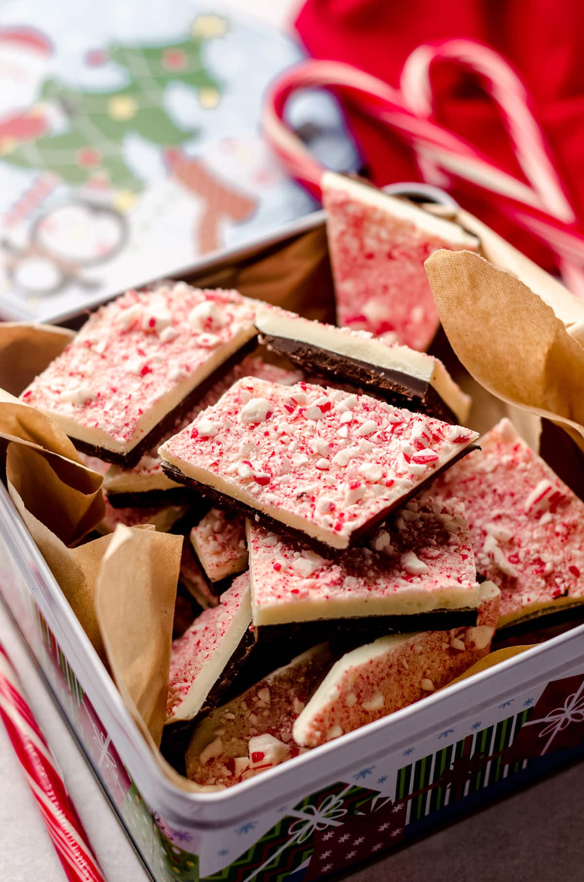 peppermint bark pieces in a tin with parchment paper