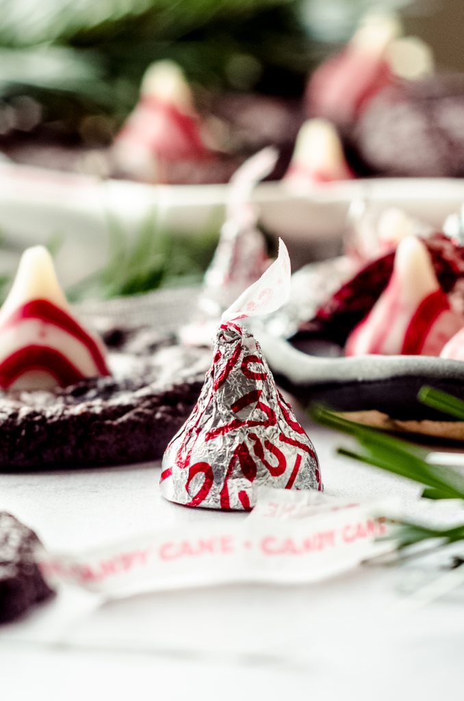 A candy cane Hershey's Kiss on a surface.