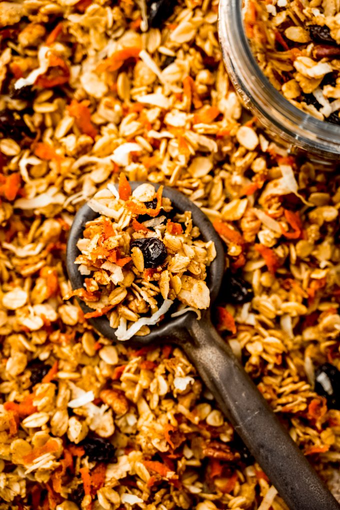 Aerial photo of a pan of soft baked carrot cake granola with a serving spoon in it.