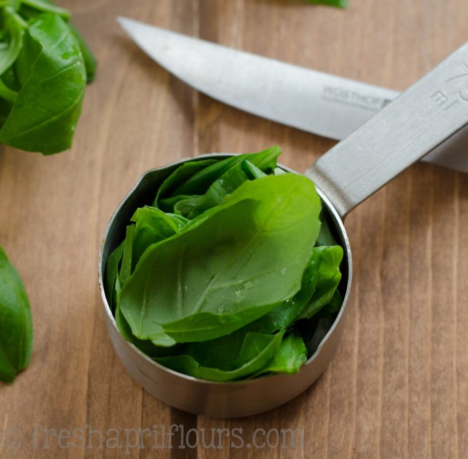 basil leaves in a measuring cup