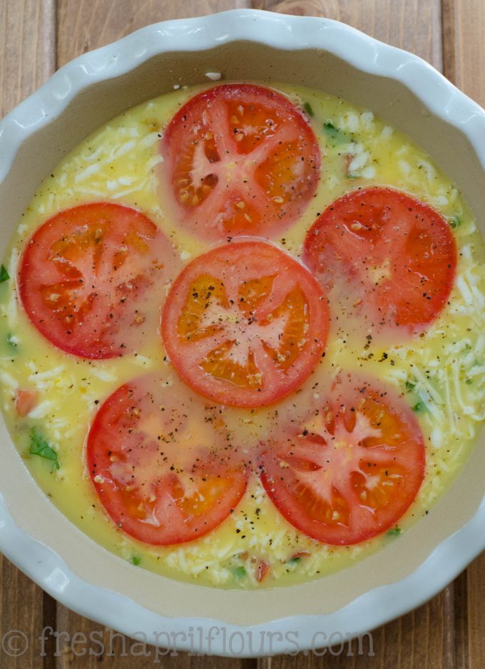 crustless caprese quiche in a pie plate ready to bake