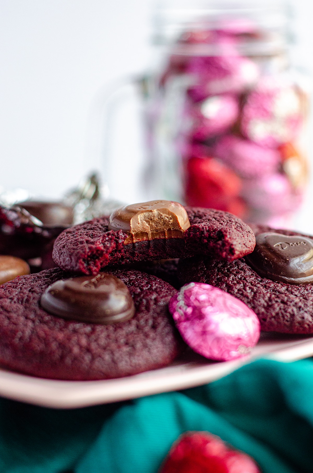 red velvet blossom cookies on a pink plate with a bite taken out of one