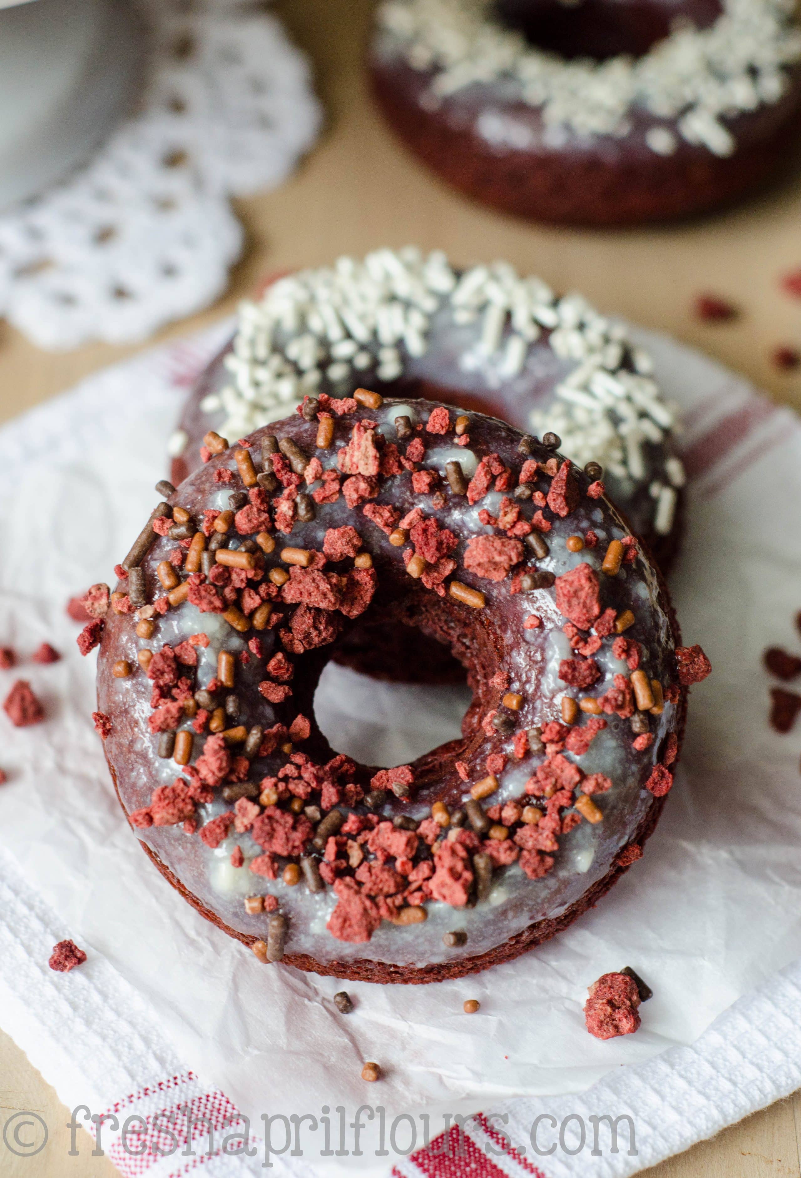 Baked Red Velvet Donuts: Fluffy, lightly sweetened and delicately tangy baked red velvet donuts topped with cream cheese glaze.