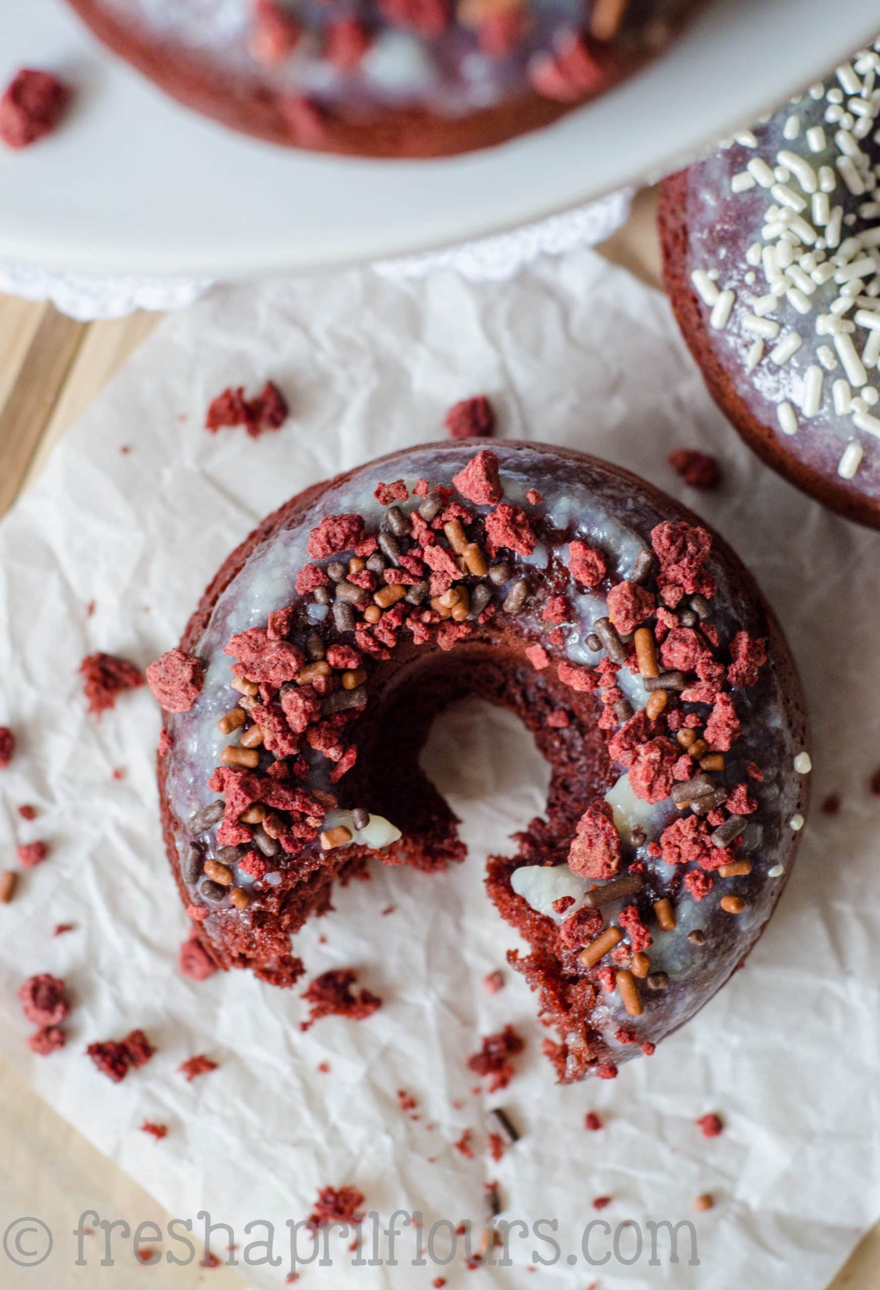 Baked Red Velvet Donuts: Fluffy, lightly sweetened and delicately tangy baked red velvet donuts topped with cream cheese glaze.