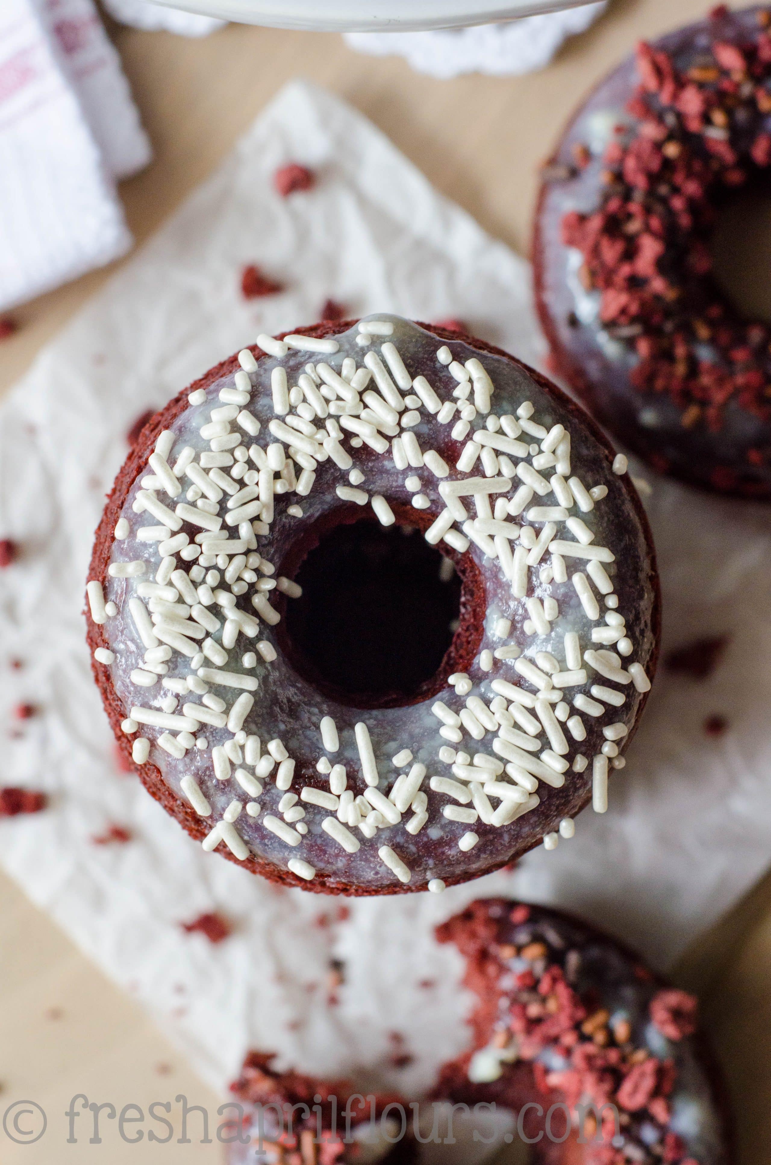 Baked Red Velvet Donuts: Fluffy, lightly sweetened and delicately tangy baked red velvet donuts topped with cream cheese glaze.