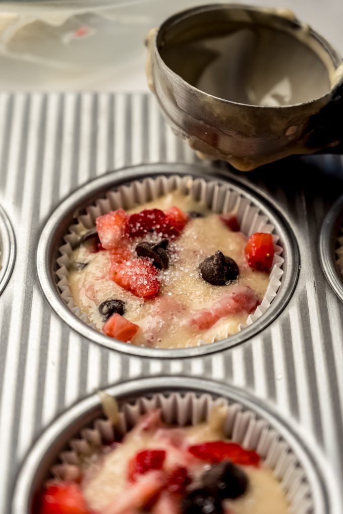 Strawberry chocolate chip muffin batter in the well of a muffin tin.