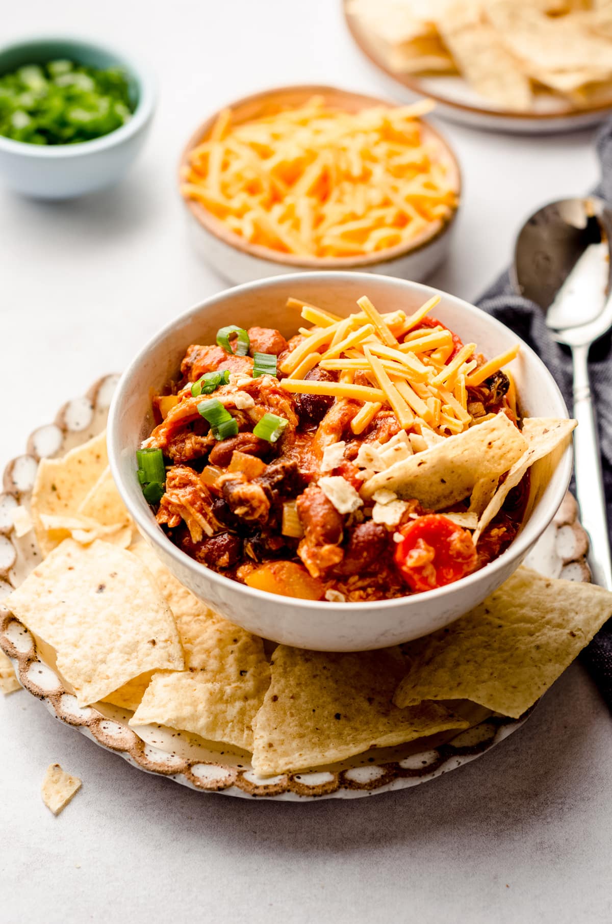 buffalo chicken chili in a bowl on a plate with tortilla chips