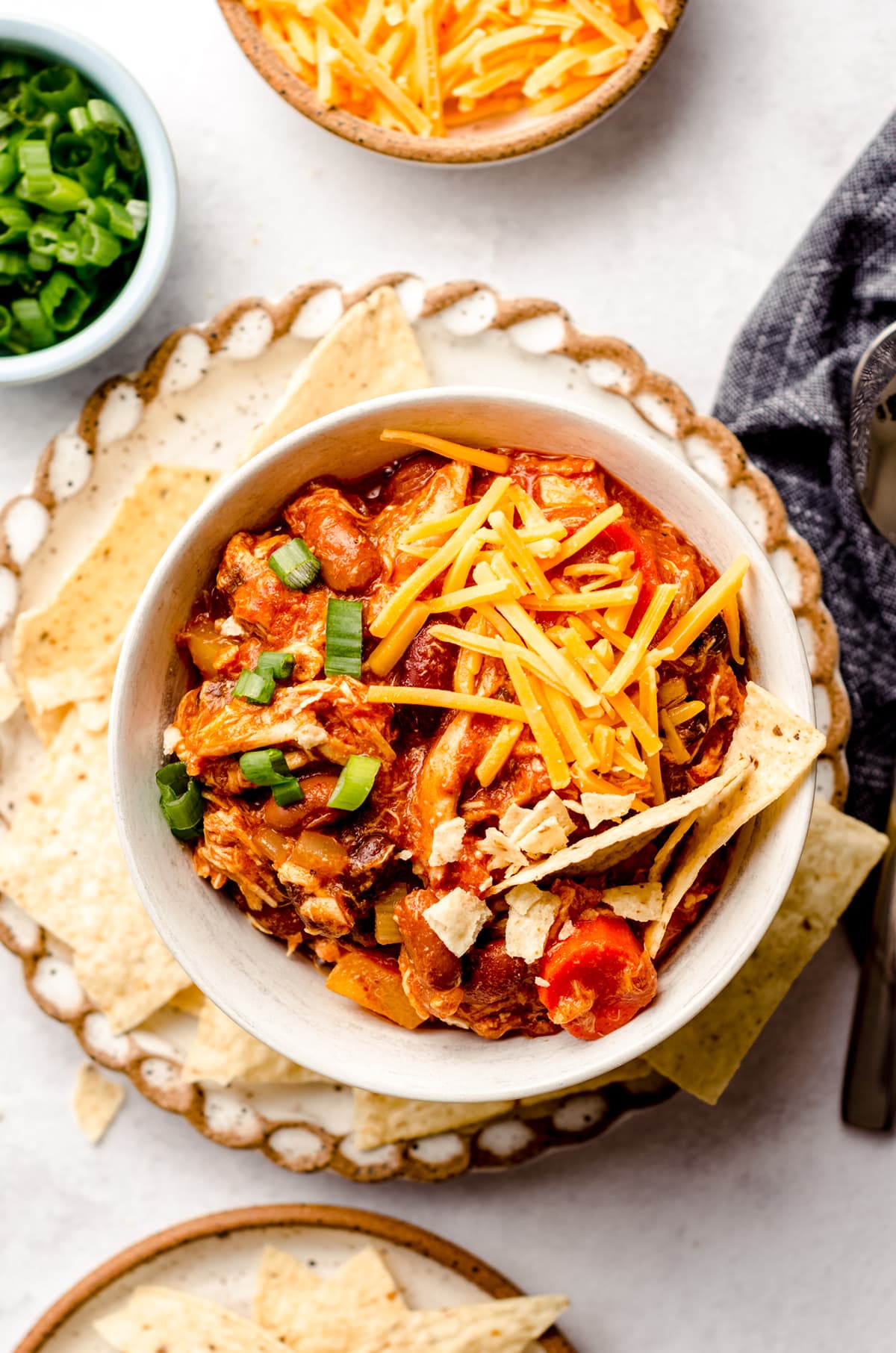 aerial photo of buffalo chicken chili in a bowl on a plate with tortilla chips