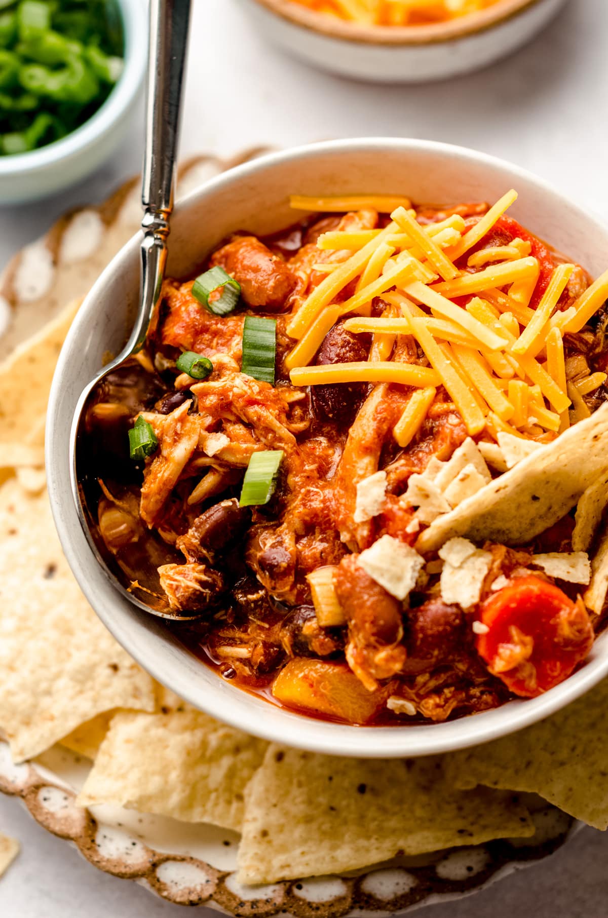 buffalo chicken chili in a bowl on a plate with tortilla chips