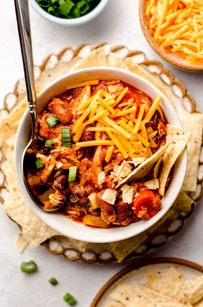 aerial photo of buffalo chicken chili in a bowl on a plate with tortilla chips