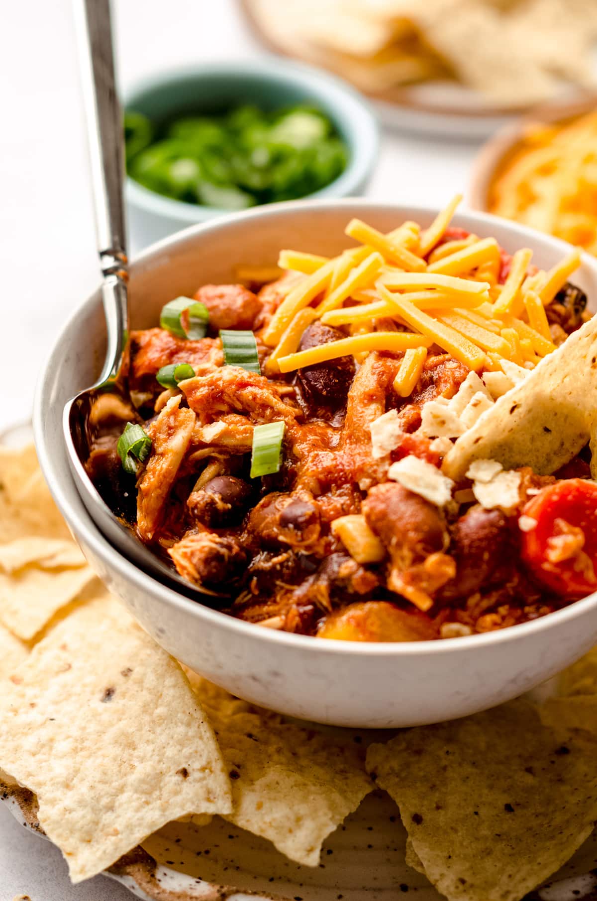 buffalo chicken chili in a bowl on a plate with tortilla chips