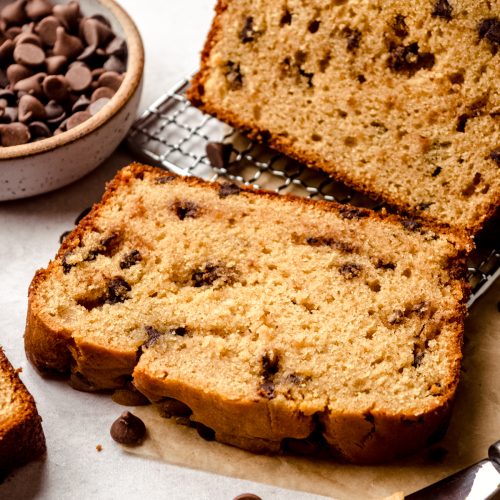 A slice of chocolate chip peanut butter bread on a wire cooling rack.